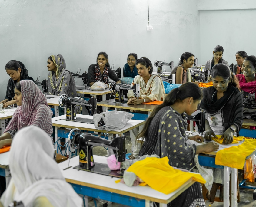 Schneiderausbildung: Frauen lernen im Nähkurs an mehreren Nähmaschinen in einem Ausbildungsraum in Bihar, Indien