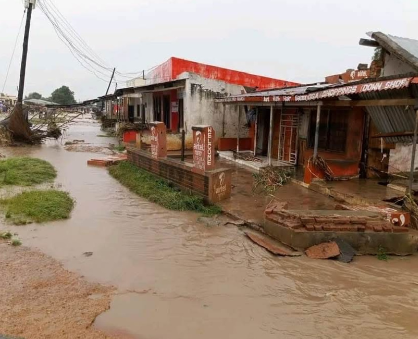 Überflutete Straße in Malawi, braunes Hochwasser und umgestürzte Strommasten blockieren den Weg