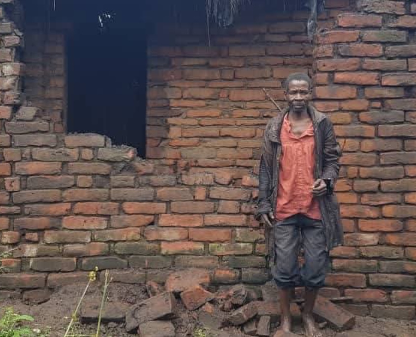 Mann in Malawi vor zerstörtem Haus