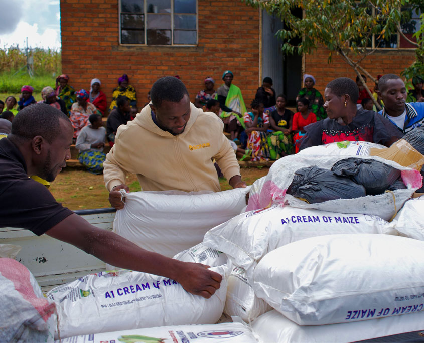 Malawi-Nothilfe-6 Eine Lieferung Maismehl, die in großen Säcken verpackt ist, wird von SONNE-Mitarbeitern ausgeladen.