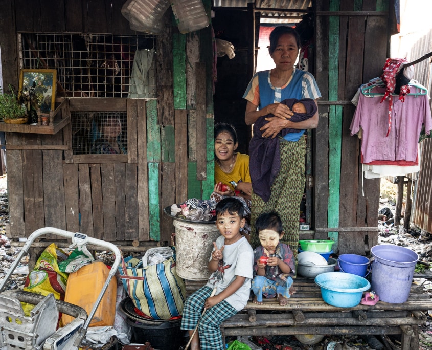 DCC4_Kinder im Slum 03 Beitrags_854_c_SONNE-International2026 Mutter mit Kindern vor Hütte im Slum in Yangon